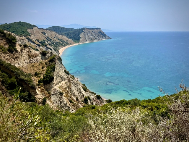 Cliffs overlooking a clear blue sea.