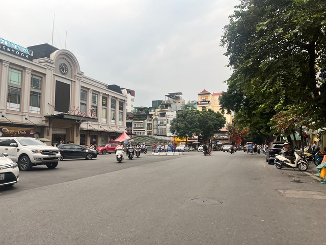 Busy street in a city with motorcycles and buildings.