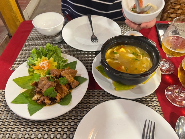 A meal with soup and meat on a beautifully arranged table.