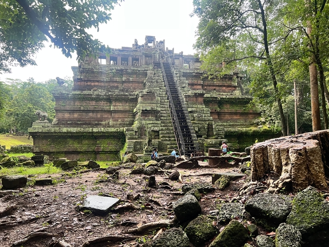 Group of visitors exploring a stone pyramid structure.