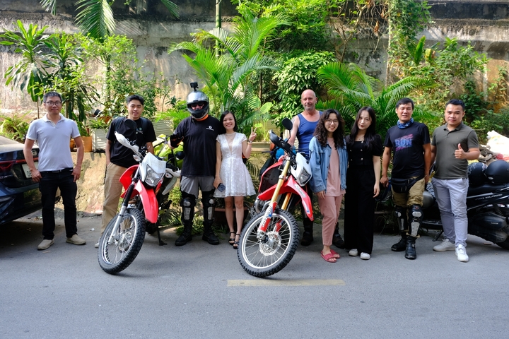 Group of people with motorbikes on a street.