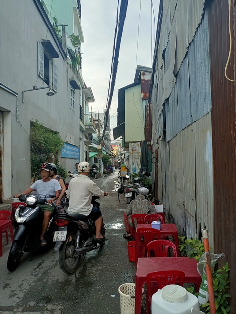 Street scene with people on motorbikes in an urban area.