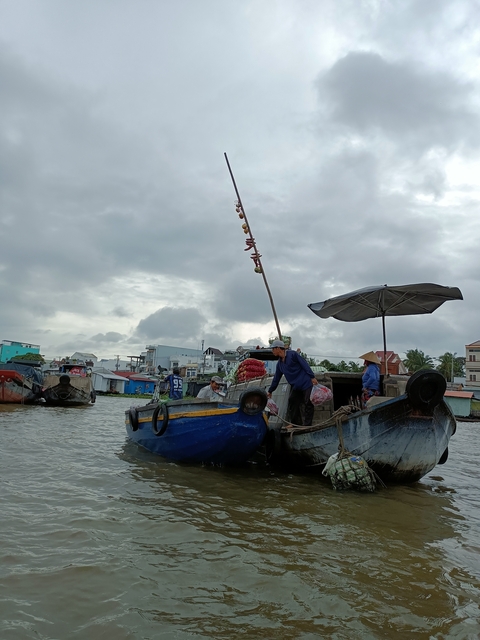 People on a boat in a floating market environment.