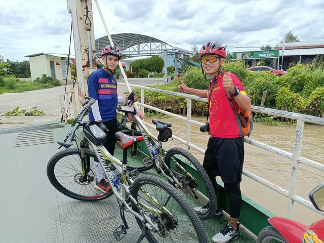 Cyclists posing with their bikes on a ferry.