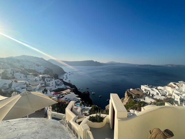 Panoramic view of a caldera and white buildings on a cliff.