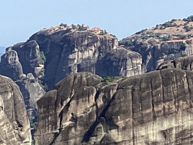 Rocky mountain landscape with distant buildings on top.