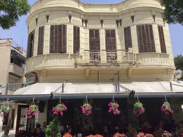 Ornate building facade with flowers hanging in front.