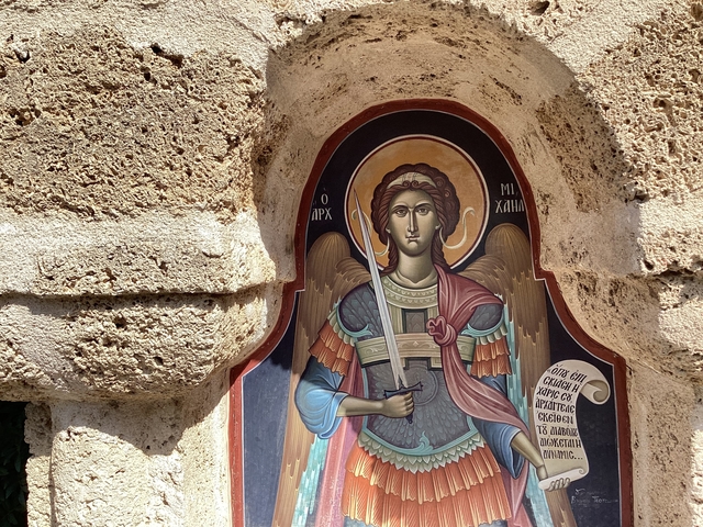Religious painting of an angel on a stone wall.