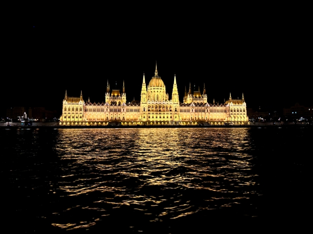 The Hungarian Parliament illuminated at night reflecting in the river.