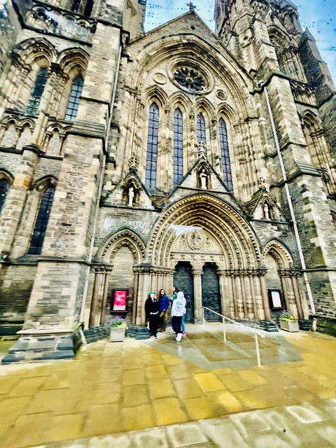 Blurry image of a cathedral entrance with people.