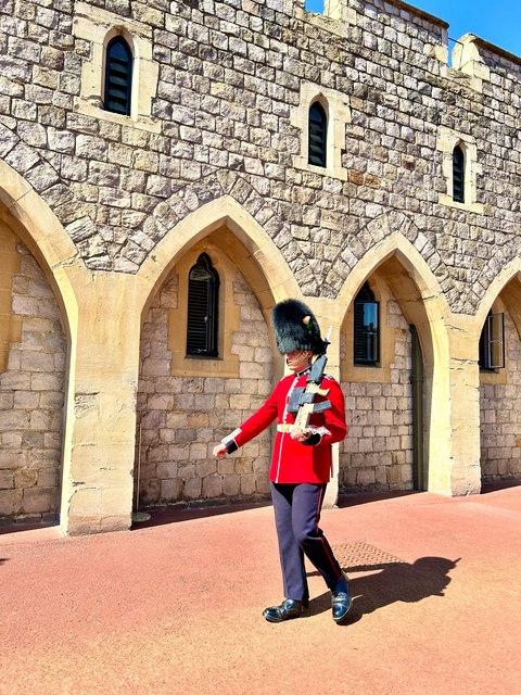 Famous guard in traditional uniform standing outside a historical building.