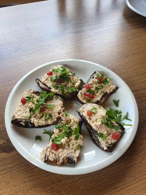 Plate of traditional appetizers with herbs and pomegranate seeds.