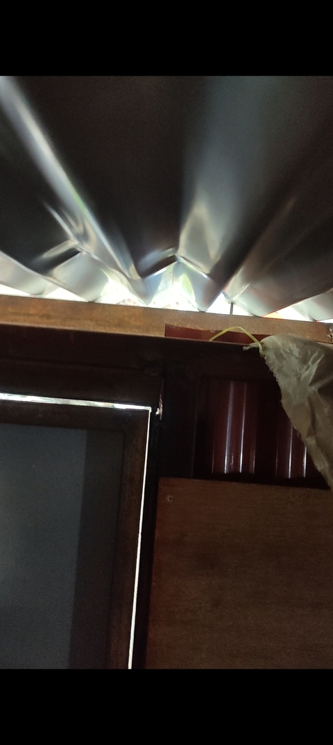 Interior view with part of a window and a corrugated roof.