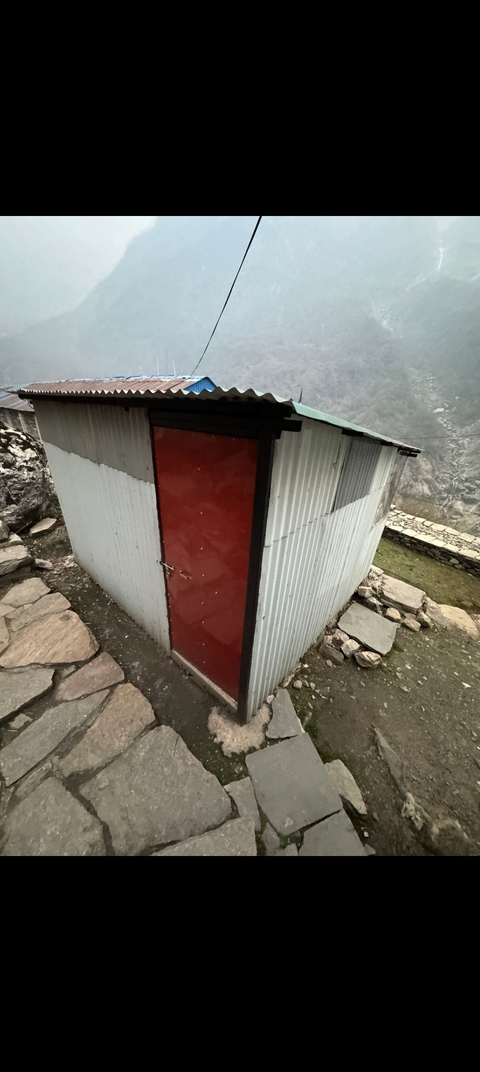 Small outdoor structure with a red door.