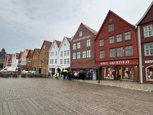 Row of colorful wooden buildings in a city square.