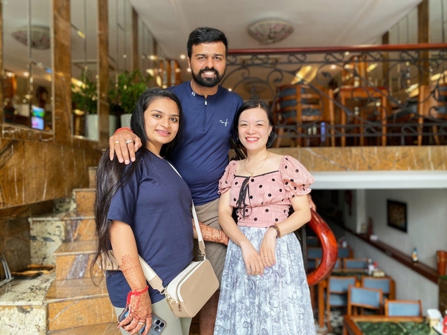 A group of three people smiling indoors.