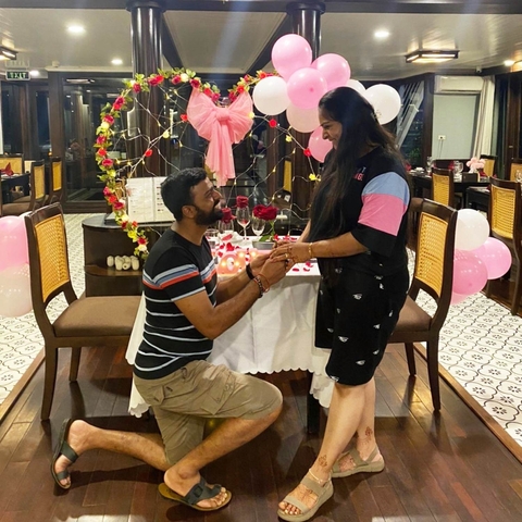 A man proposing to a woman at a romantically decorated table.