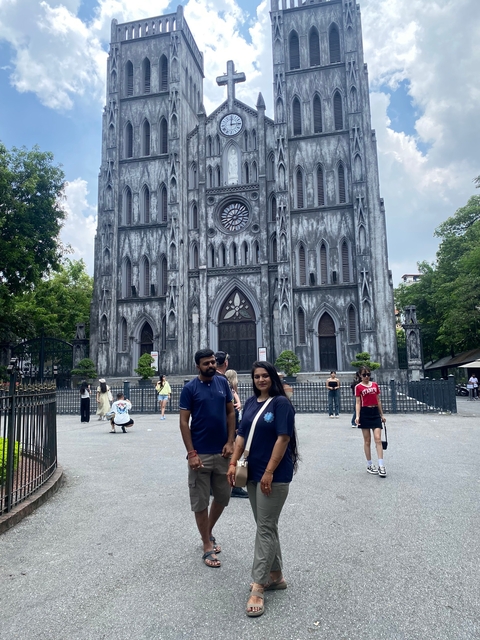 A couple posing in front of a cathedral.