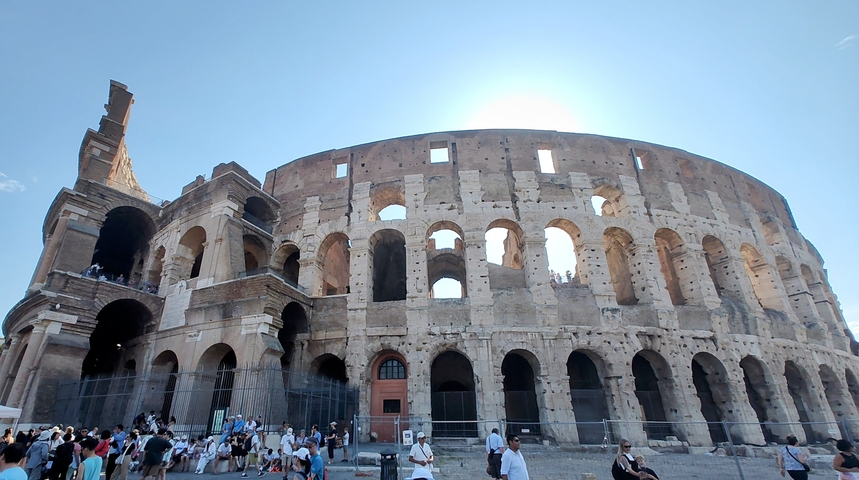 The Colosseum in Rome with tourists gathered below.