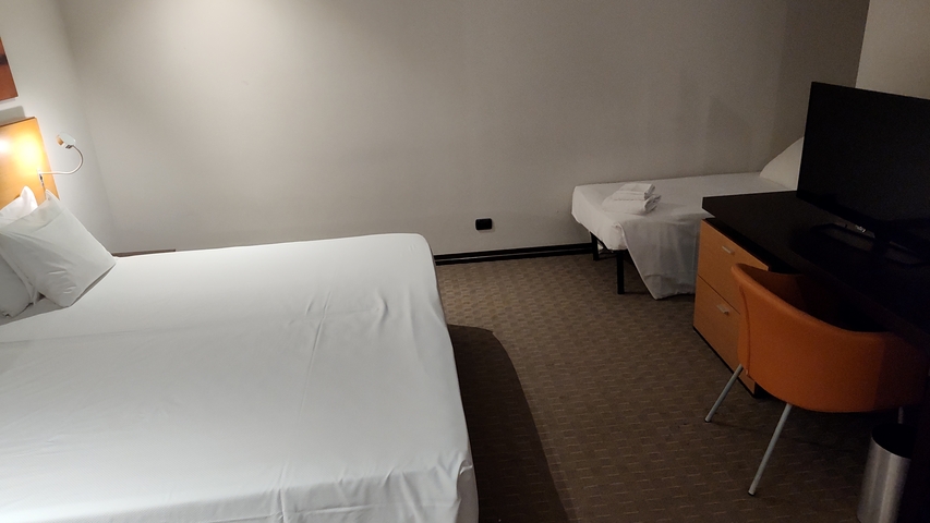 Basic hotel room with a large bed and TV.