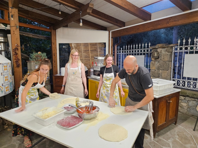 People making pizza in a kitchen.