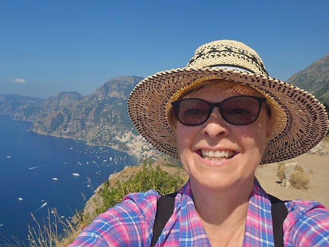 Woman taking a selfie with a coastal view.