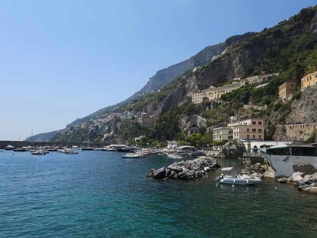 Coastal view with buildings on the hillside.