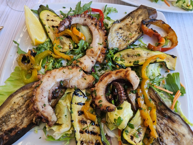 Plate of grilled octopus and vegetables.