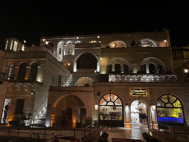 Nighttime view of a beautifully lit historical building with restaurant signage.