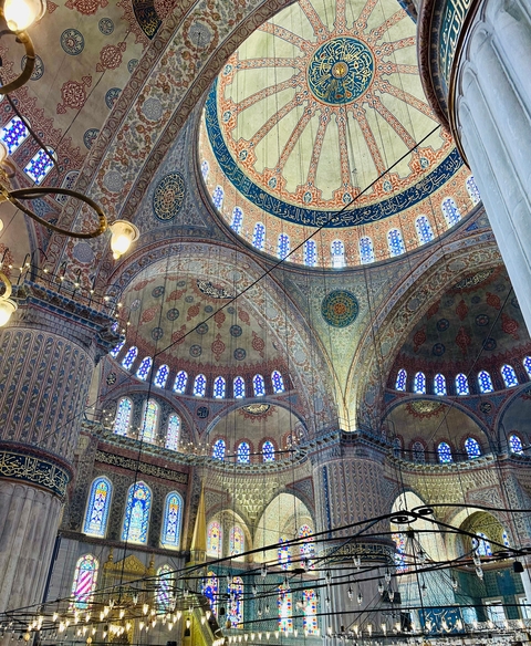 Ornately decorated interior dome with intricate designs and stained glass.