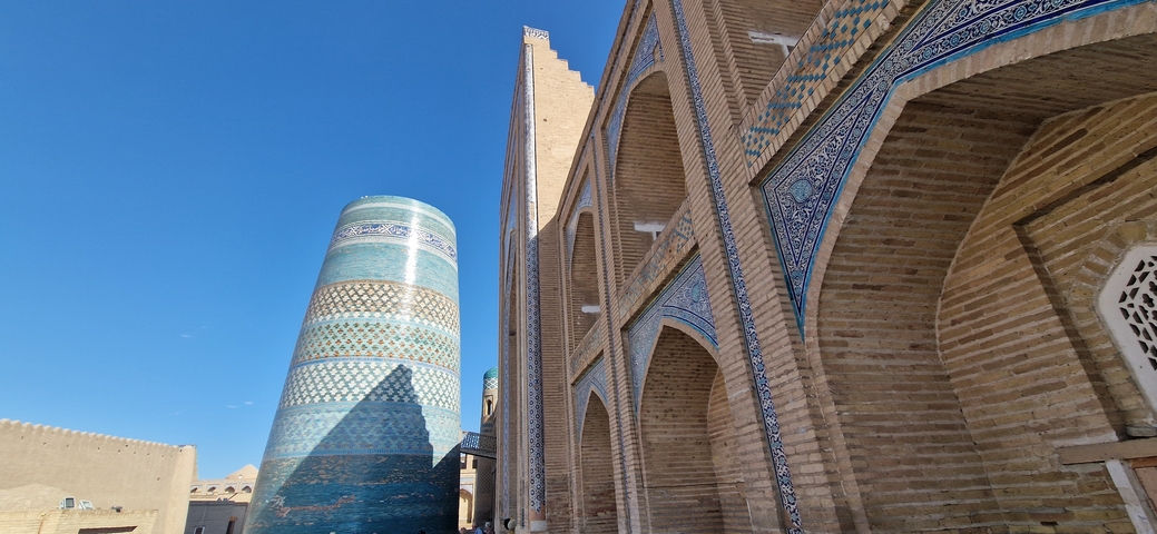 Historic minaret with blue tiles against a clear sky