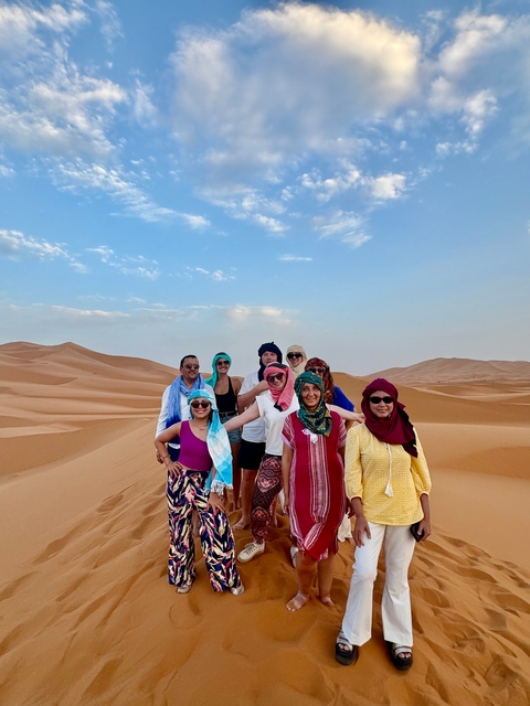 A group of people posing in the desert landscape.