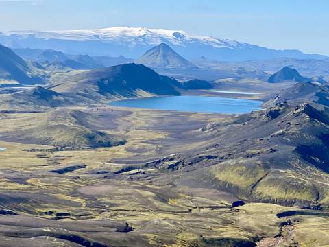 Vast aerial view of mountains and a lake in a serene landscape.