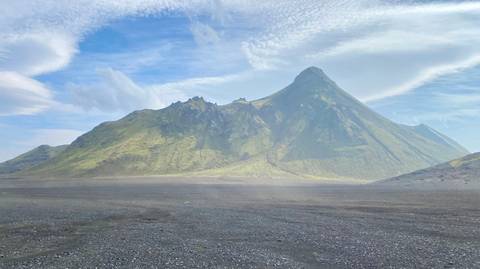 Tall mountain peak with clear skies and calm surroundings.