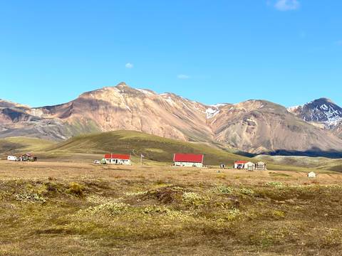 Colorful mountain range and isolated houses in a rural setting.