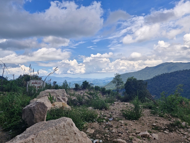 Mountain landscape with clouds and patches of blue sky.