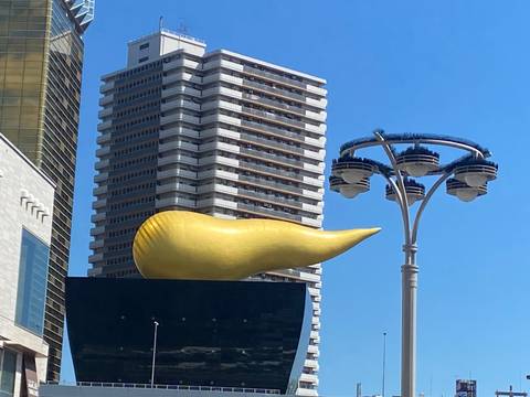 Modern architecture with a notable golden sculpture on top of a building.