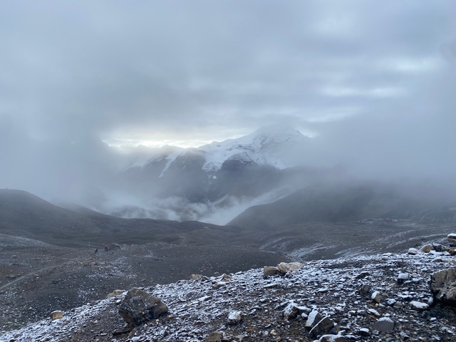 Snowy mountain landscape with clouds settling on the peaks.