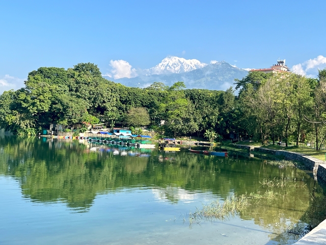 Lake with boats and mountains in the background.