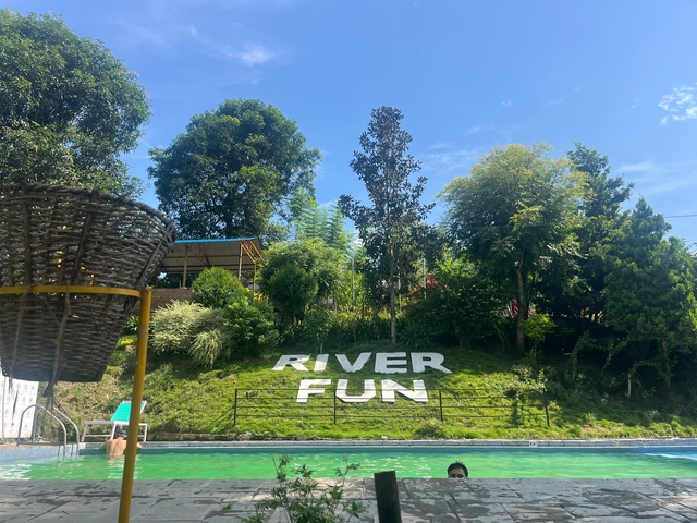 River Fun sign on a grassy hill with trees.
