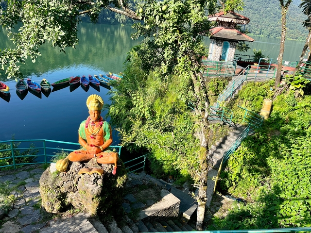 Boats on a lake with a colorful statue in the foreground.
