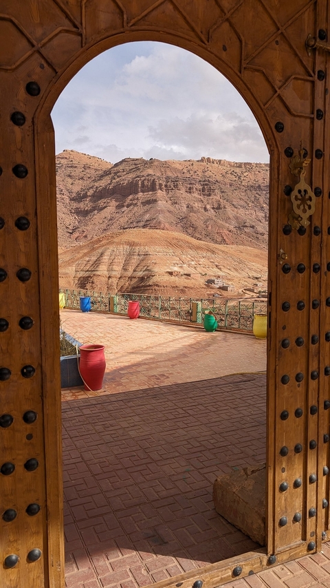 Colorful pots on a terrace overlooking a rocky landscape.