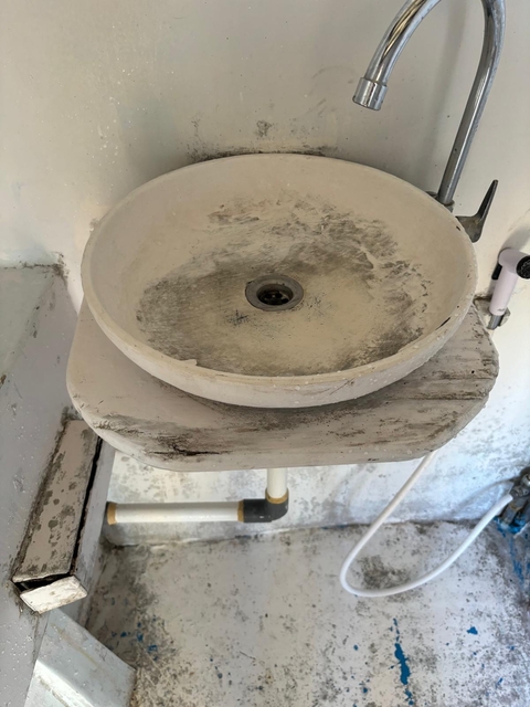 Dirty bathroom sink with a rustic appearance.