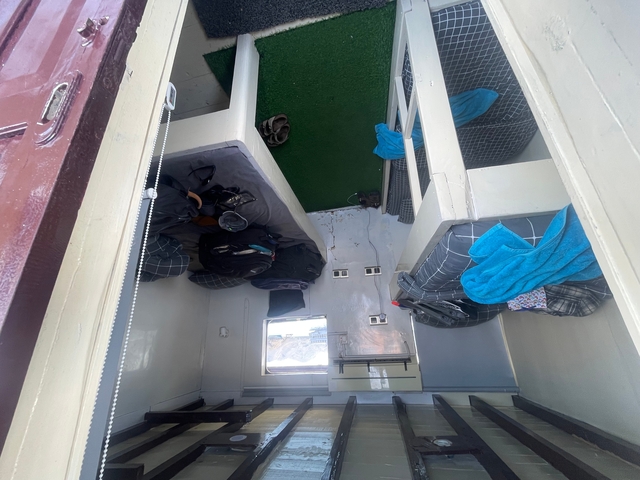 Interior bunk setup with bags and towels.