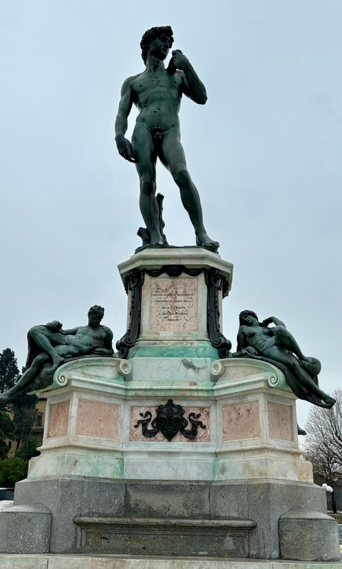 A statue of a nude figure on a pedestal with ornate detailing.