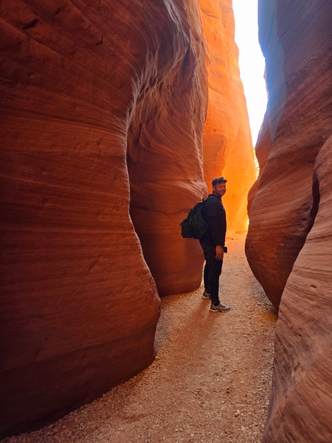 Person standing between narrow red canyon walls