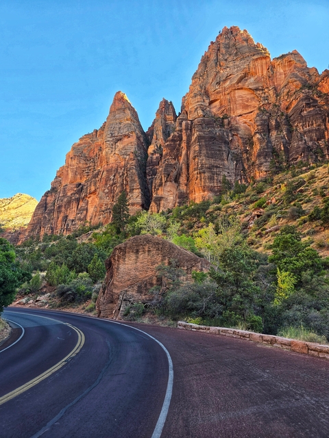Scenic view of red rock cliffs and green foliage