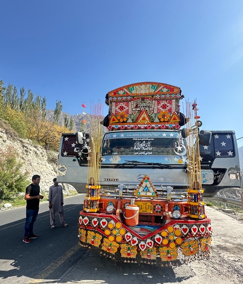 A decorated truck on a road in a mountainous area.