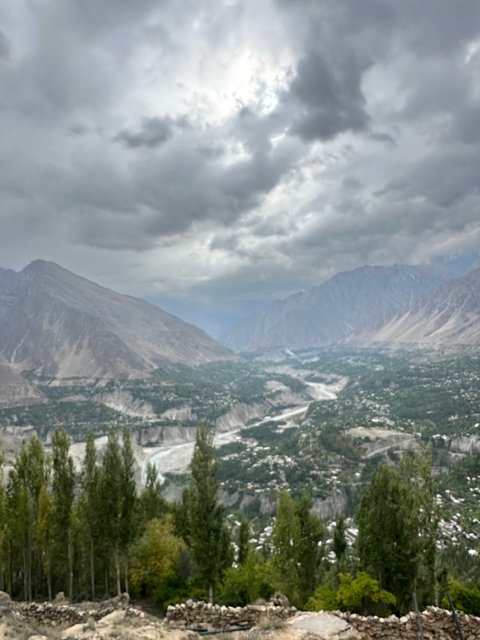 Blurry image of a valley and mountains under cloudy skies.