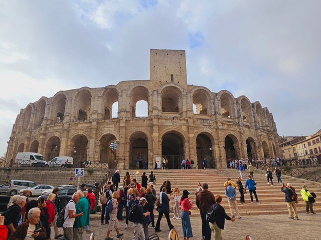 Historic Roman amphitheater filled with tourists.